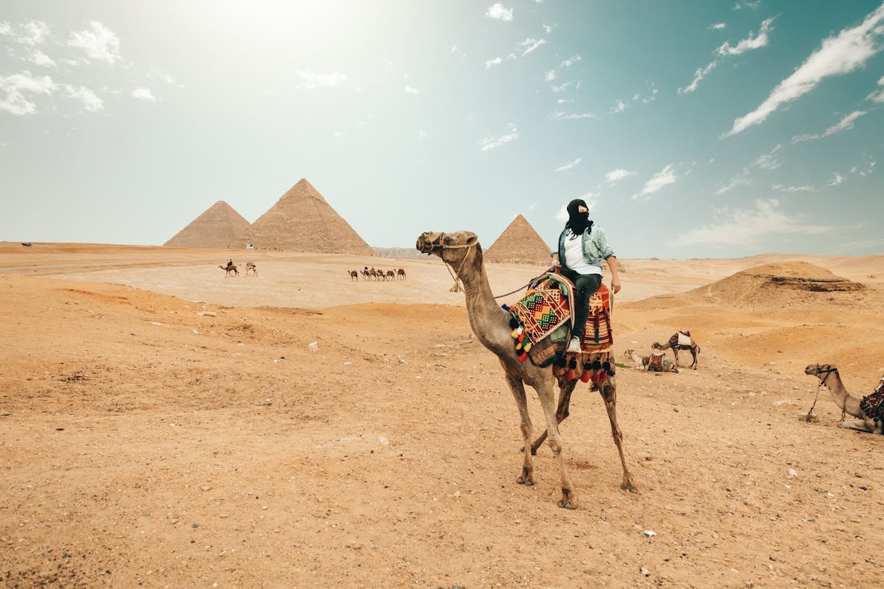 Tourist riding camel while exploring desert